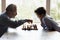 Elderly granddad teaching little boy grandkid to play chess game