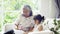 Elderly grandma reading book with little granddaughter on couch