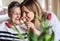 An elderly grandmother with an adult granddaughter at home, smelling flowers.