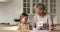 Elderly grandmother check granddaughter knowledge show cards with multiplication tasks