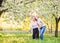 Elderly grandmother with crutch and granddaughter in spring nature.