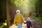 Elderly grandmother and her little grandchild walking together in sunny summer park. Grandma and grandson