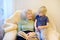 Elderly grandmother and little grandchild reading a book at home. Grandma and grandson