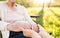 Elderly grandmother in wheelchair with granddaughter in spring nature.