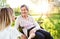 Elderly grandmother in wheelchair with granddaughter in spring nature.