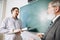 Elderly gray-headed man, professor, teacher and student at lecture, lesson at classroom, indoors. Concept of