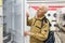 elderly grayhaired man pensioner looking refrigerator at counter in showroom of electrical appliance hypermarket