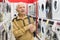 elderly grayhaired man pensioner looking washing machine at counter in showroom of electrical appliance hypermarket