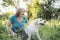 Elderly grayhaired woman with her dog in the park