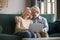 Elderly grey-haired spouse laughing and enjoying leisure time with computer.