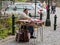 An elderly gypsy sells a raspberry at the entrance to the park is located not far from the Pelesh castle in Sinaia in Romania