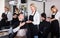 Elderly hairdresser serving teenager