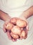 Elderly hands holding fresh potatoes with vintage style