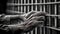 Elderly hands holding prison bars