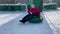 Elderly happy Caucasian woman rolls down snow slide on a tubing. Winter entertainment and active sport. Recreation and