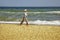 Elderly happy woman running on the beach along the coast near sea