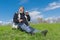 Elderly hiker sitting on green hill