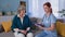 elderly home care, woman therapist and old female pensioner talking about medical treatment while sitting on couch