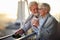 An elderly hugged couple in love spending a wonderful time together while enjoying a beautiful sunset from the terrace of their