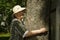 Elderly hugging tree trunk her hands in the forest