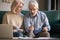 Elderly husband and wife calculate finances paying bills online