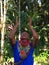 Elderly indigenous shaman of Cofan nationality performing a healing ritual with his arms raised in the Amazon jungle seen from the