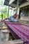 Elderly Indonesian lady works on the loom
