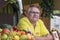 An elderly interesting man in glasses smiles selling fruit smoothies at a street food festival in the town of Hale (Sale), German