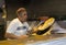 An elderly Jewish male in a colourful hat making pita bread in a small home bakery near the Mahane Yehuda market in Jerusalem