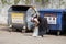 Elderly lady hoarder puts empty beer bottles in a bag