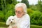 Elderly lady holding a little white Havanese dog