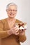 Elderly lady holding small present box smiling