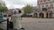 Elderly lady sits and takes tourist photos in an historic Dutch town square