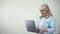 Elderly lady surprised with message on laptop, modern technologies for retirees