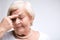 Elderly lady touching her head with finger