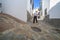 Elderly local man climbing slope narrow street of Comares, Malaga, Spain