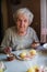 An elderly lone woman eats at home.