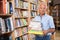 Elderly male buyer with pile of literature books in bookshop