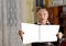 Elderly male pensioner reading a newspaper