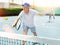 Elderly male player serving ball during training tennis in court outdoors