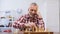 Elderly male playing chess alone and looking to camera preparing for competition