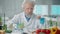 Elderly male researcher examines a sample of genetically modified meat in a petri dish. The microbiologist analyzes the