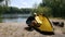 Elderly male retired tourist put a sleeping bag in the tent. Green tourism, hiking.