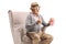 Elderly man with 3d glasses and popcorn sitting in an armchair