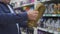 An elderly man chooses engine oil at an auto shop. Close-up of the hand