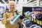 elderly man choosing iron in showroom of electrical appliance store