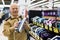 elderly man choosing iron in showroom of electrical appliance store