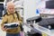 Elderly man choosing robot vacuum cleaner in showroom of electrical appliance store