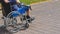 Elderly man with diabetes and kidney disease sitting on wheelchair walking with assistant in the park