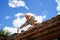 an elderly man dismantles the old brickwork and lays new bricks on the roof.